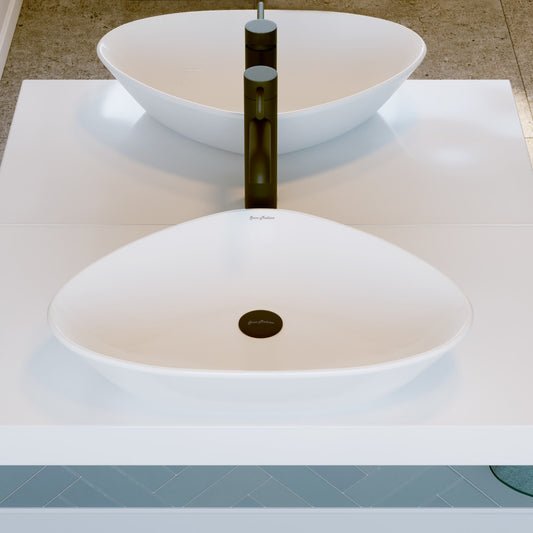 Oval white ceramic vessel sink with smooth curved edges and black drain center.