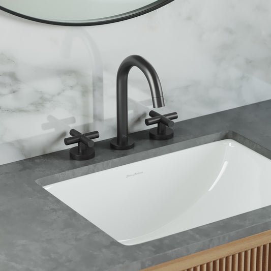 Widespread bathroom faucet in matte black with cross handles and arched spout over white sink.